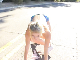 Slender blonde with nude boobies is doing exercises outdoors